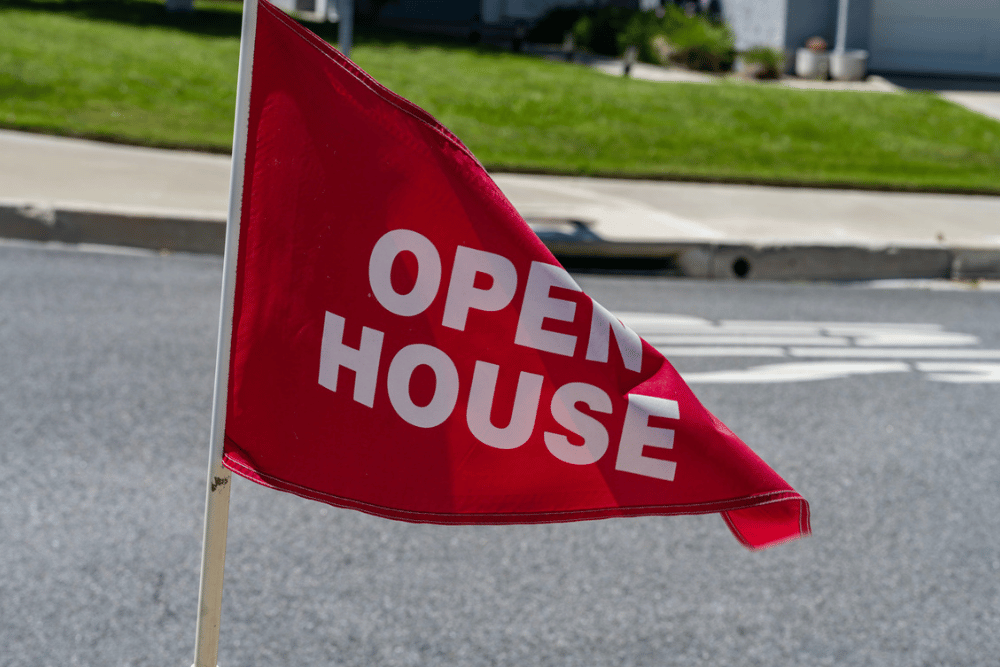 A red open house promotional flag signaling the upcoming opening of a new site.