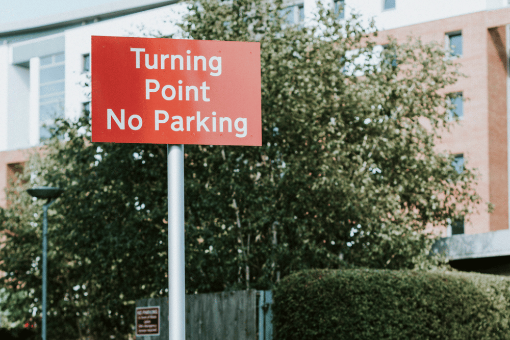 A red and white outdoor sign illustrating the importance of waterproof signage.