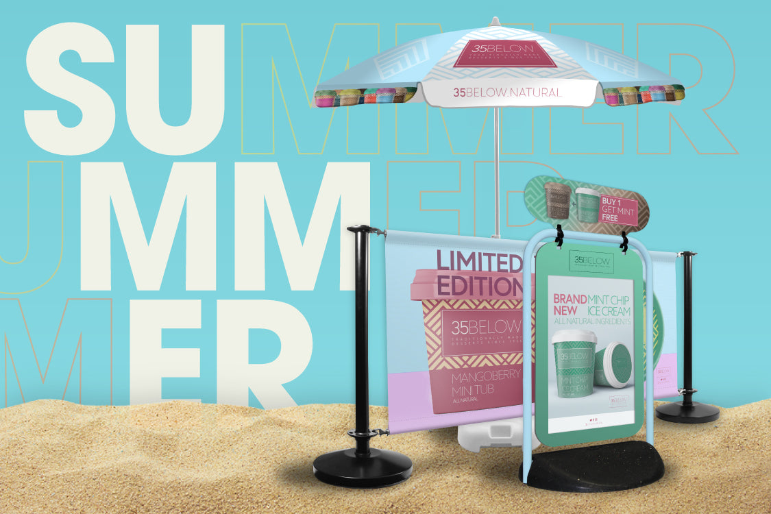 Summer point of sale signage on a beach themed background showing a Classic Garden Parasol, Satin Black Adfresco Cafe Barrier, and a Swinger 2 with Tactical Header.
