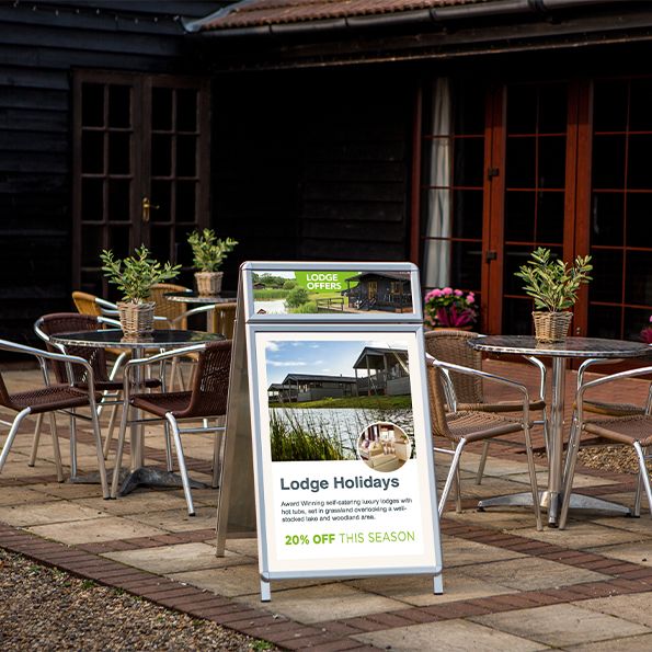 Outdoor seating area with a promotional sign for Lodge Holidays.
